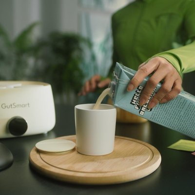 Close-up of wellness routine preparation with starter culture packets and wooden serving accessories