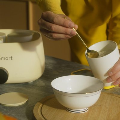 Yoga practitioner in green attire performing an advanced balance pose in a zen-inspired home studio with bamboo artwork